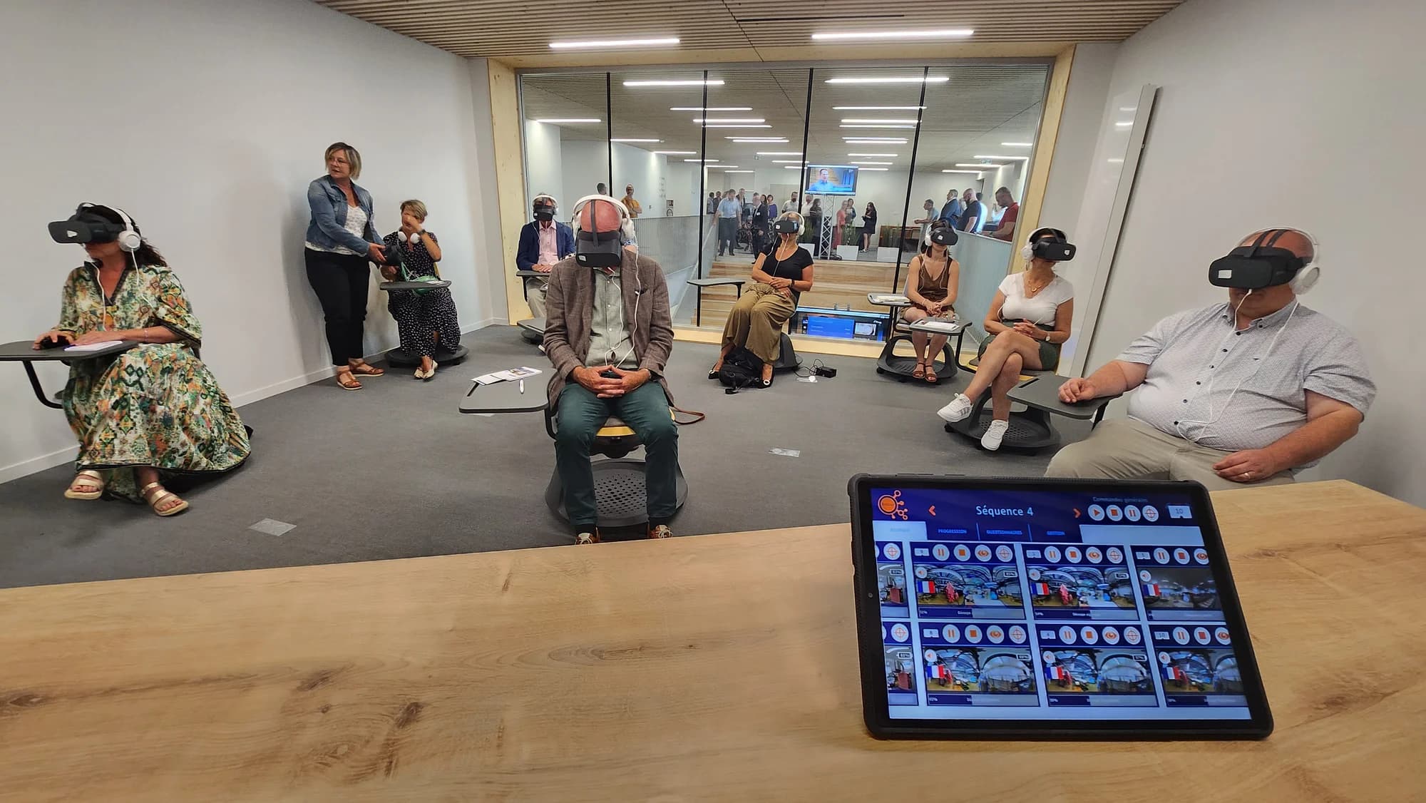 Groupe d'apprenants en formation sécurité VR multilingue, avec tablette de pilotage
