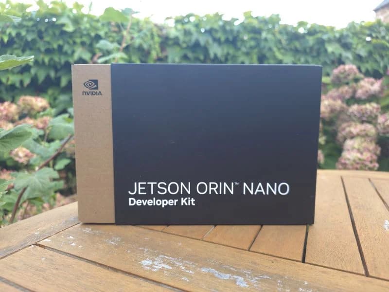 Le carton scellé du kit de développement NVIDIA Jetson Orin Nano, posé sur une table de jardin en bois, le jour de sa réception
